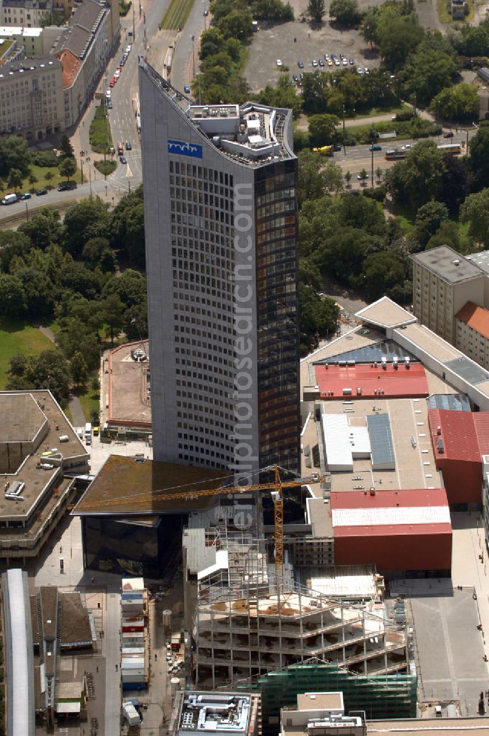 Aerial photograph Leipzig - Blick auf die Bauarbeiten am Paulinum am Augustusplatz. An dieser Stelle entsteht seit 2005 der neue innerstädtische Campus der Universität Leipzig mit dem Paulinum, dem Nachfolger der 1968 gesprengten Paulinerkirche. Die Diskussion um die Wiedererrichtung der Kirche verzögerte den Baubeginn: Ursprünglich sollte der Bau rein architektonisch an die Paulinerkirche erinnern, der Universität aber als multifunktionale Aula dienen. Ein Wiederaufbau als Universitätskirche wurde von Universität und Bevölkerung abgelehnt. Die Bürgerinitiative Paulinerverein konnte jedoch mit Hilfe des Vatikans und der sächsischen Landesregierung durchsetzen, dass das Paulinum ein katholisches Gotteshaus werden soll. Der Erweiterungsbau sollte zum 600. Jubiläum der Universität im Jahr 2009 fertiggestellt sein, der Zeitrahmen konnte aus verschiedenen Gründen nicht eingehalten werden. Mit im Bild das Hochhaus des MDR. Kontakt: Universität Leipzig, Ritterstraße 26, 04109 Leipzig, Tel. +49(0)341 97108, Fax +49(0)341 9730099