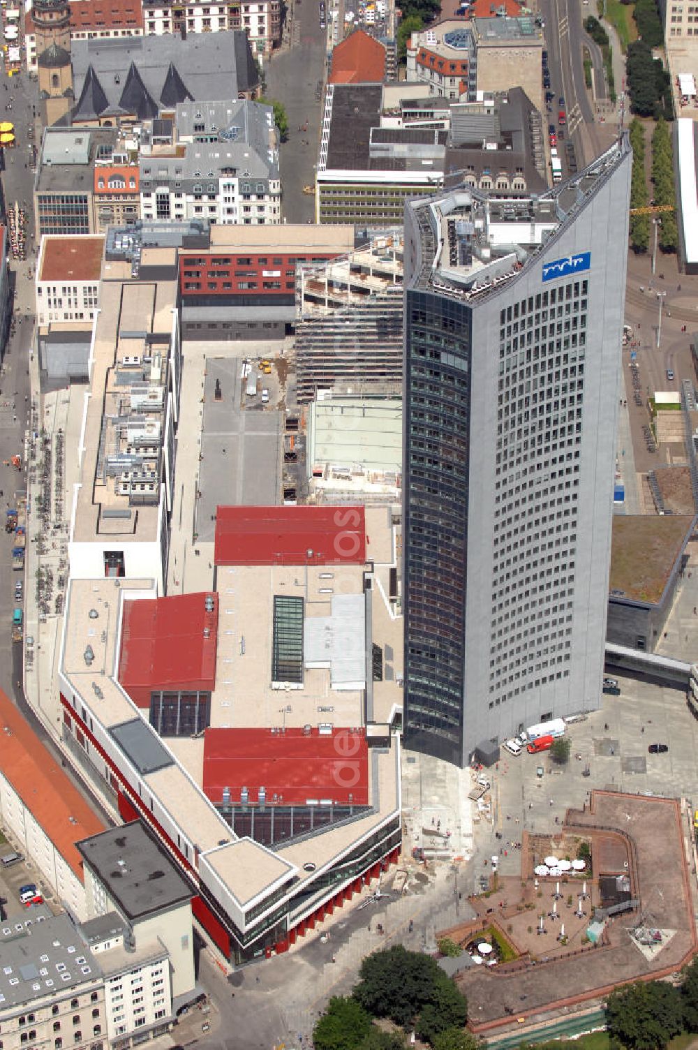 Aerial image Leipzig - Blick auf die Bauarbeiten am Paulinum am Augustusplatz. An dieser Stelle entsteht seit 2005 der neue innerstädtische Campus der Universität Leipzig mit dem Paulinum, dem Nachfolger der 1968 gesprengten Paulinerkirche. Die Diskussion um die Wiedererrichtung der Kirche verzögerte den Baubeginn: Ursprünglich sollte der Bau rein architektonisch an die Paulinerkirche erinnern, der Universität aber als multifunktionale Aula dienen. Ein Wiederaufbau als Universitätskirche wurde von Universität und Bevölkerung abgelehnt. Die Bürgerinitiative Paulinerverein konnte jedoch mit Hilfe des Vatikans und der sächsischen Landesregierung durchsetzen, dass das Paulinum ein katholisches Gotteshaus werden soll. Der Erweiterungsbau sollte zum 600. Jubiläum der Universität im Jahr 2009 fertiggestellt sein, der Zeitrahmen konnte aus verschiedenen Gründen nicht eingehalten werden. Mit im Bild das Hochhaus des MDR. Kontakt: Universität Leipzig, Ritterstraße 26, 04109 Leipzig, Tel. +49(0)341 97108, Fax +49(0)341 9730099