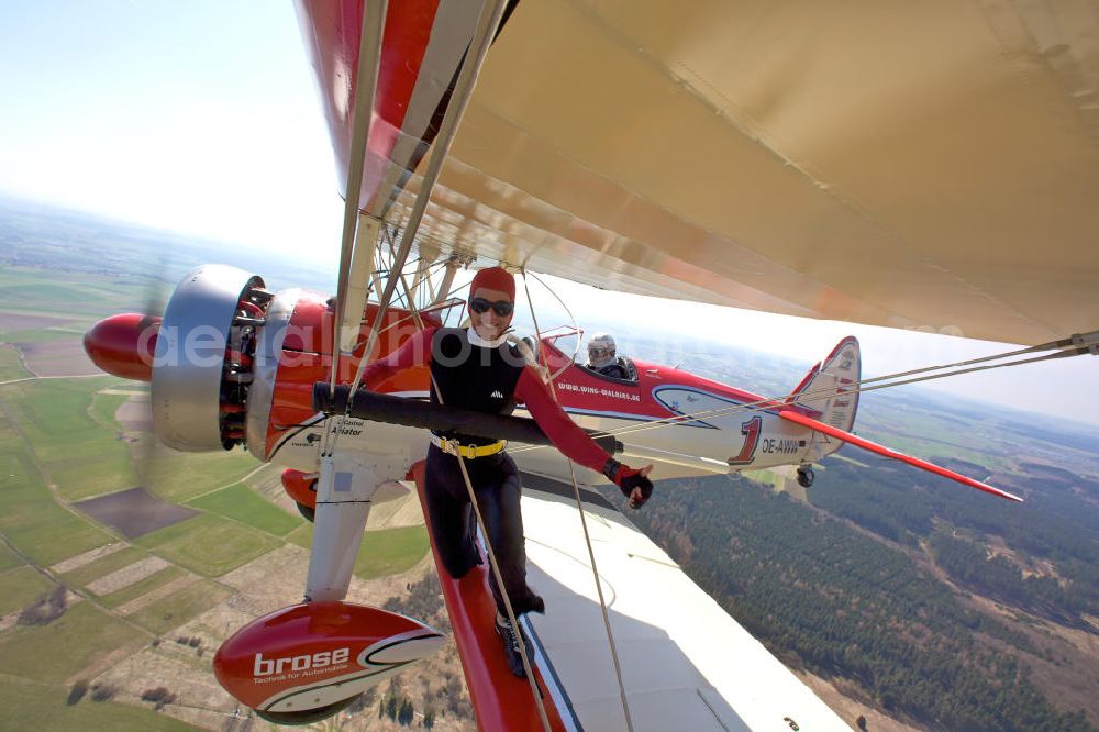 Aerial photograph Kirchheim unter Teck OT Hahnweide - Wenn Peggy Krainz das Cockpit ihrer Stearman verlässt, hat sie einige hundert Meter Luft unter sich. Die Wingwalkerin und ihre Co- Pilotin Verena Dolderer zeigen ein atemberaubendes Ausstiegsszenario aus dem einmotorigen Doppeldecker. Die aufwendig restaurierte Boeing Stearman PT-17, Baujahr 1942, seit Anfang 2005 österreichisch registriert, ist bis zu 350 km/h schnell und speziell für das Wingwalking umgebaut.