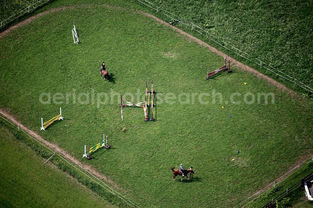Linda from the bird's eye view: Horse parcour and horse riders in Linda in the state of Thuringia. The children are riding on the led horses on a paddock. The vaulting green belongs to the riding facilities Linda