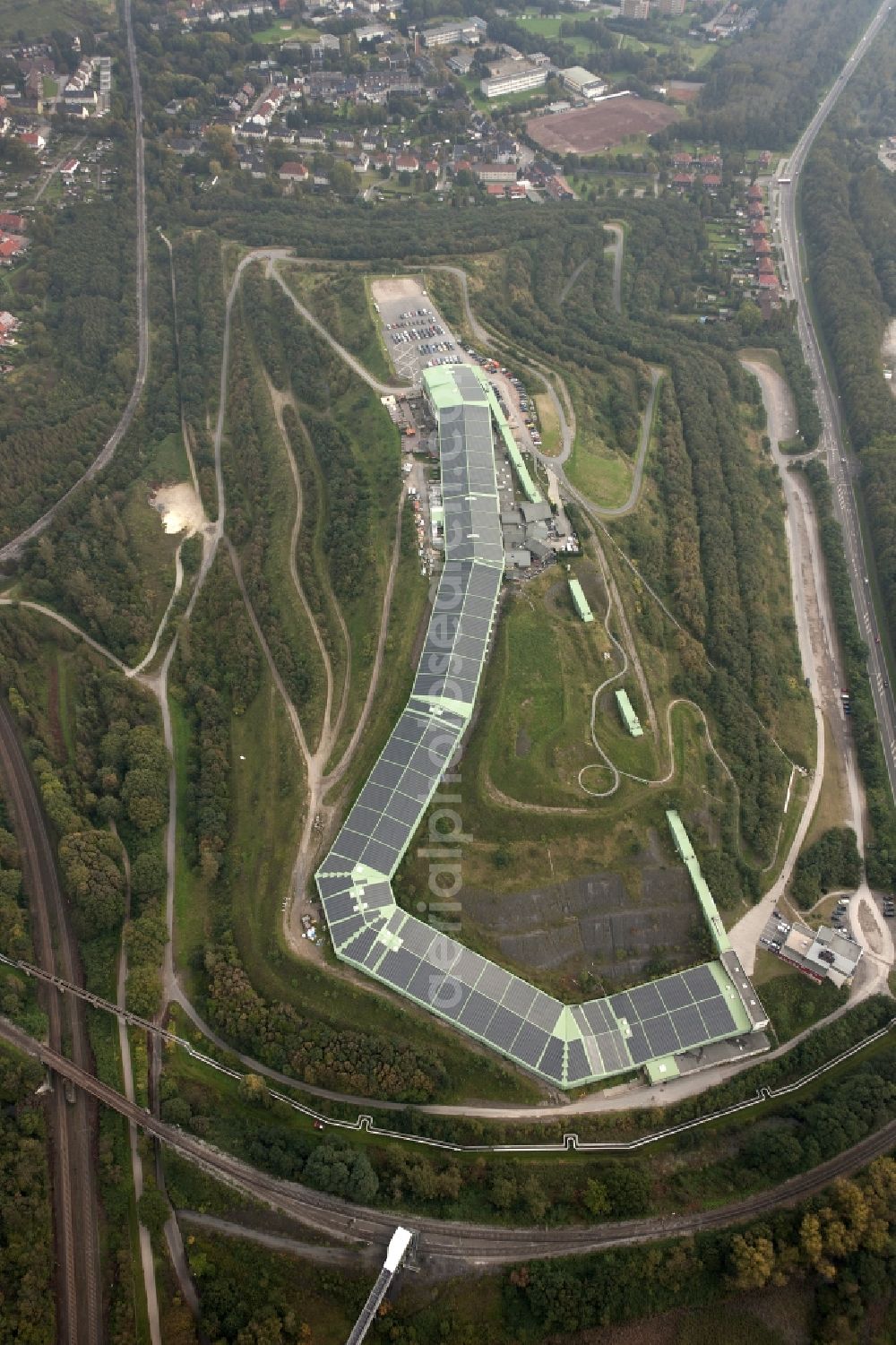 Aerial photograph Bottrop - Photovoltaic system - solar power plant on the roof of the summer toboggan run on the heap in Bottrop in North Rhine-Westphalia