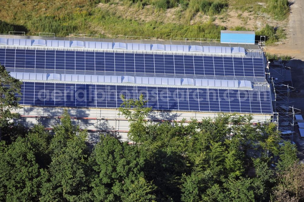 Großostheim OT Ringheim from the bird's eye view: Großostheim 07/23/2012 view of a photovoltaic / solar power plant as a combination of open spaces and roof systems in the industrial park Großostheim in state of Bavaria. A project of Conecon GmbH