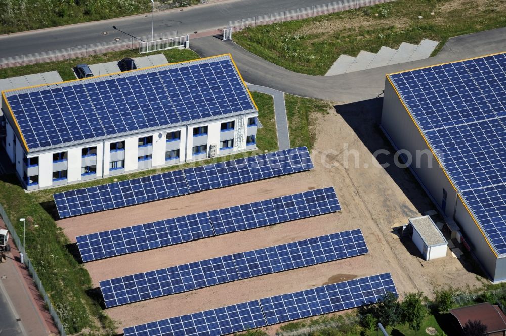 Großostheim OT Ringheim from the bird's eye view: Großostheim 07/23/2012 view of a photovoltaic / solar power plant as a combination of open spaces and roof systems in the industrial park Großostheim in state of Bavaria. A project of Conecon GmbH