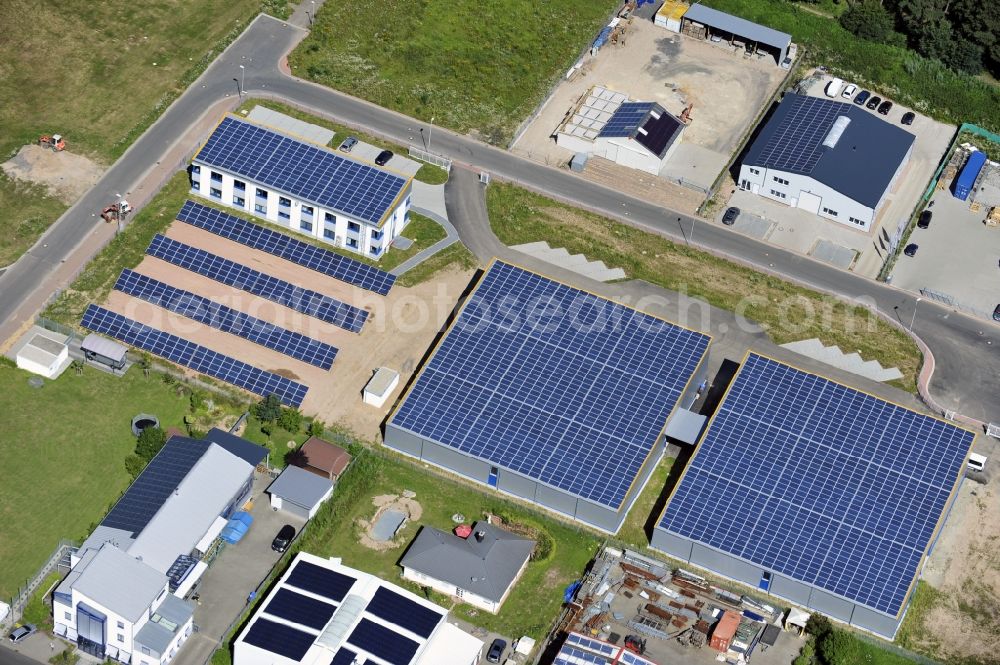 Großostheim OT Ringheim from the bird's eye view: Großostheim 07/23/2012 view of a photovoltaic / solar power plant as a combination of open spaces and roof systems in the industrial park Großostheim in state of Bavaria. A project of Conecon GmbH