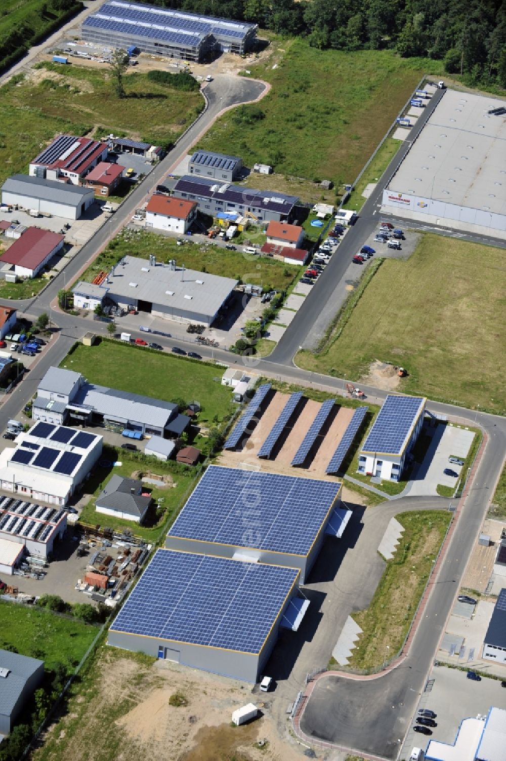 Großostheim OT Ringheim from above - Großostheim 07/23/2012 view of a photovoltaic / solar power plant as a combination of open spaces and roof systems in the industrial park Großostheim in state of Bavaria. A project of Conecon GmbH