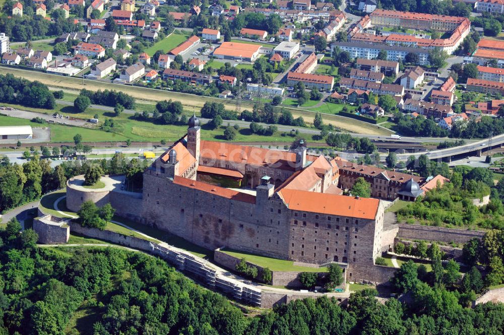 Kulmbach from above - Die Plassenburg in Kulmbach, Bayern. Aufgrund ihrer militärischen Stärke und künstlerischen Ausgestaltung genoss die Burganlage in früheren Jahrhunderten einen fast legendären Ruf. Im dritten Reich beherbergte sie die Reichsschule der deutschen Technik, heutzutage befinden sich hier das staatliche Museum Die Hohenzollern in Franken , das Armeemuseum Friedrich der Große, das Landschaftsmuseum Obermain und das Deutsche Zinnfigurenmuseum. Desweiteren finden auf dem Gelände immer wieder Ausstellungen statt. Es befindet sich im Besitz des Freistaats Bayern. Castle Plassenburg in Kulmbach, Bavaria. Several museums are located here.