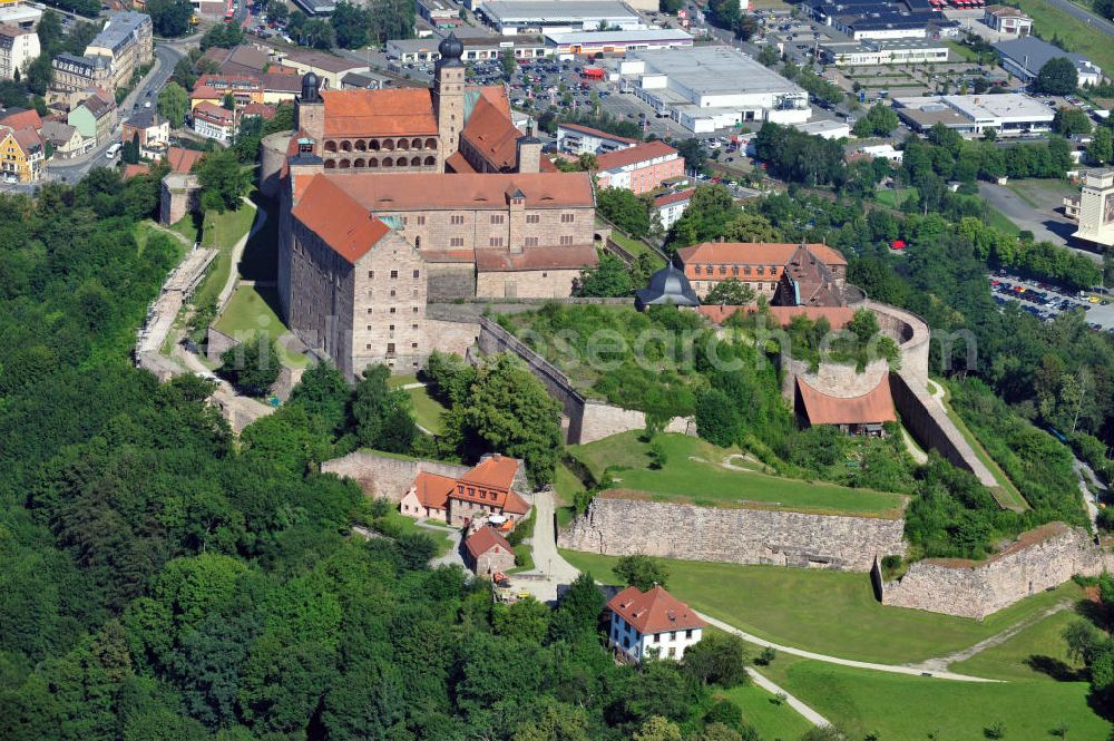 Kulmbach from above - Die Plassenburg in Kulmbach, Bayern. Aufgrund ihrer militärischen Stärke und künstlerischen Ausgestaltung genoss die Burganlage in früheren Jahrhunderten einen fast legendären Ruf. Im dritten Reich beherbergte sie die Reichsschule der deutschen Technik, heutzutage befinden sich hier das staatliche Museum Die Hohenzollern in Franken , das Armeemuseum Friedrich der Große, das Landschaftsmuseum Obermain und das Deutsche Zinnfigurenmuseum. Desweiteren finden auf dem Gelände immer wieder Ausstellungen statt. Es befindet sich im Besitz des Freistaats Bayern. Castle Plassenburg in Kulmbach, Bavaria. Several museums are located here.