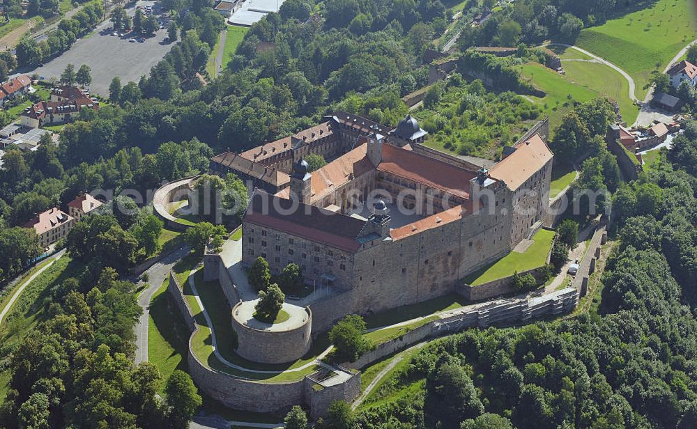 Kulmbach from above - Die Plassenburg in Kulmbach, Bayern. Aufgrund ihrer militärischen Stärke und künstlerischen Ausgestaltung genoss die Burganlage in früheren Jahrhunderten einen fast legendären Ruf. Im dritten Reich beherbergte sie die Reichsschule der deutschen Technik, heutzutage befinden sich hier das staatliche Museum Die Hohenzollern in Franken , das Armeemuseum Friedrich der Große, das Landschaftsmuseum Obermain und das Deutsche Zinnfigurenmuseum. Desweiteren finden auf dem Gelände immer wieder Ausstellungen statt. Es befindet sich im Besitz des Freistaats Bayern. Castle Plassenburg in Kulmbach, Bavaria. Several museums are located here.