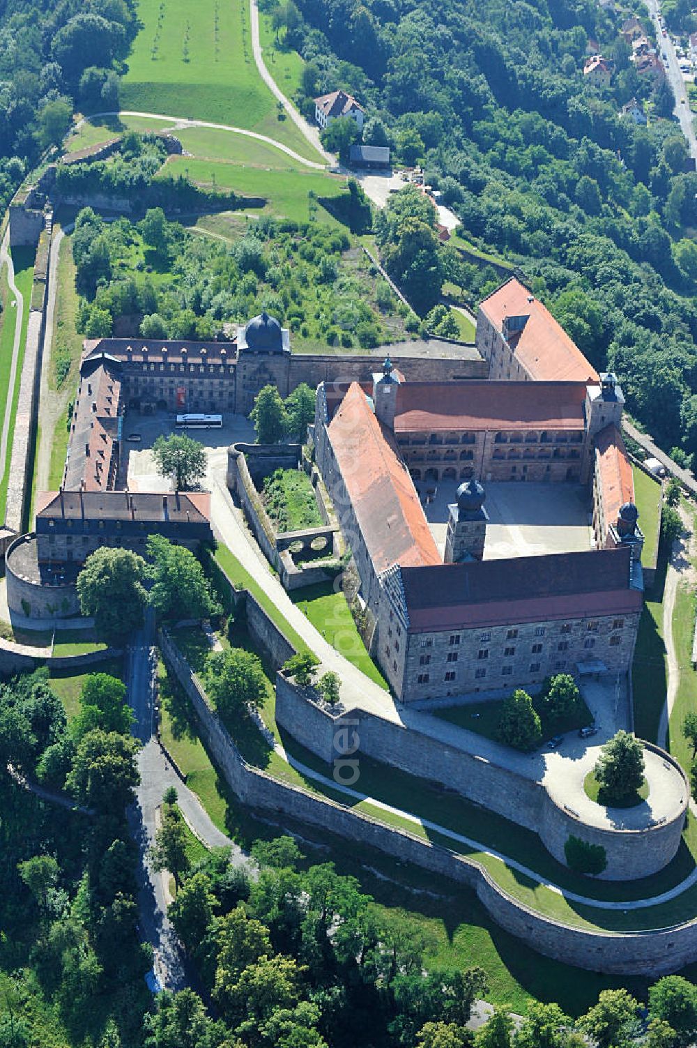 Aerial image Kulmbach - Die Plassenburg in Kulmbach, Bayern. Aufgrund ihrer militärischen Stärke und künstlerischen Ausgestaltung genoss die Burganlage in früheren Jahrhunderten einen fast legendären Ruf. Im dritten Reich beherbergte sie die Reichsschule der deutschen Technik, heutzutage befinden sich hier das staatliche Museum Die Hohenzollern in Franken , das Armeemuseum Friedrich der Große, das Landschaftsmuseum Obermain und das Deutsche Zinnfigurenmuseum. Desweiteren finden auf dem Gelände immer wieder Ausstellungen statt. Es befindet sich im Besitz des Freistaats Bayern. Castle Plassenburg in Kulmbach, Bavaria. Several museums are located here.