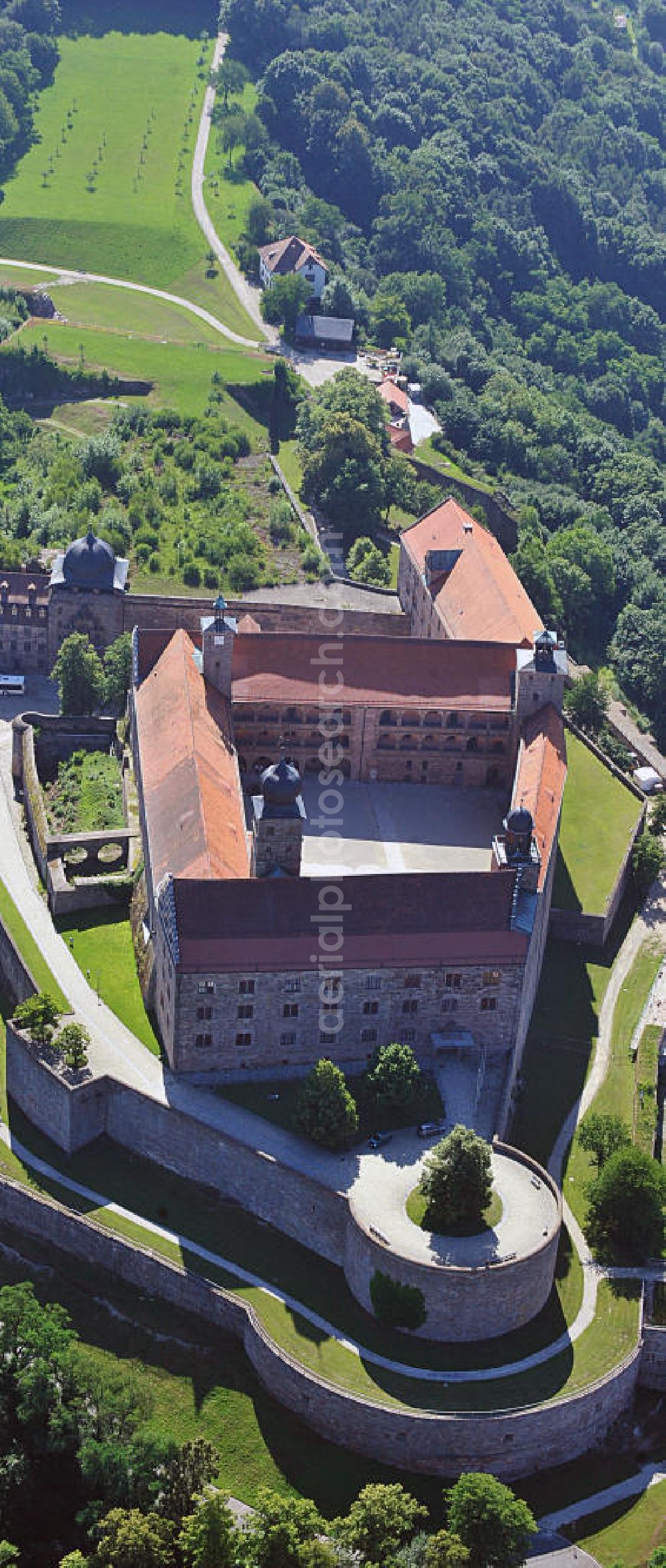 Aerial photograph Kulmbach - Die Plassenburg in Kulmbach, Bayern. Aufgrund ihrer militärischen Stärke und künstlerischen Ausgestaltung genoss die Burganlage in früheren Jahrhunderten einen fast legendären Ruf. Im dritten Reich beherbergte sie die Reichsschule der deutschen Technik, heutzutage befinden sich hier das staatliche Museum Die Hohenzollern in Franken , das Armeemuseum Friedrich der Große, das Landschaftsmuseum Obermain und das Deutsche Zinnfigurenmuseum. Desweiteren finden auf dem Gelände immer wieder Ausstellungen statt. Es befindet sich im Besitz des Freistaats Bayern. Castle Plassenburg in Kulmbach, Bavaria. Several museums are located here.