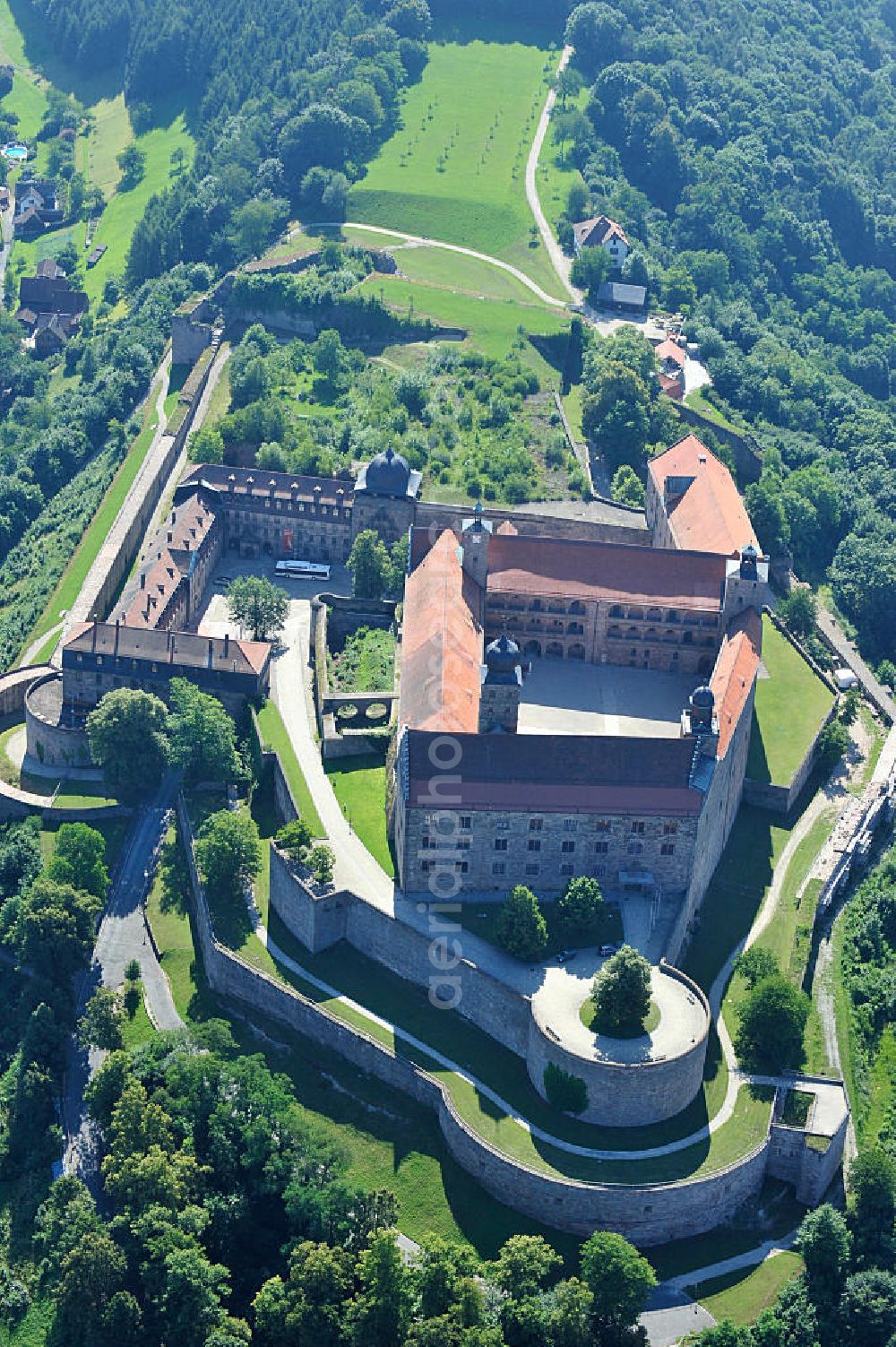 Kulmbach from above - Die Plassenburg in Kulmbach, Bayern. Aufgrund ihrer militärischen Stärke und künstlerischen Ausgestaltung genoss die Burganlage in früheren Jahrhunderten einen fast legendären Ruf. Im dritten Reich beherbergte sie die Reichsschule der deutschen Technik, heutzutage befinden sich hier das staatliche Museum Die Hohenzollern in Franken , das Armeemuseum Friedrich der Große, das Landschaftsmuseum Obermain und das Deutsche Zinnfigurenmuseum. Desweiteren finden auf dem Gelände immer wieder Ausstellungen statt. Es befindet sich im Besitz des Freistaats Bayern. Castle Plassenburg in Kulmbach, Bavaria. Several museums are located here.