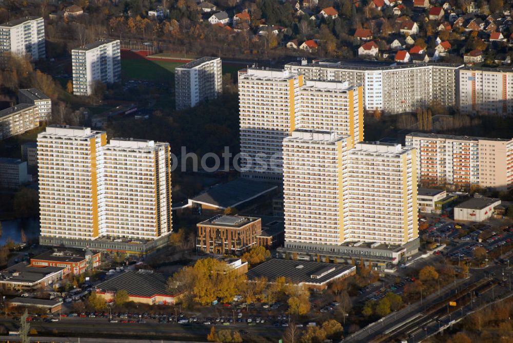 Aerial image Berlin-Marzahn - Blick auf die Plattenbausiedlung am Helene-Weigel-Platz in Berlin-Marzahn. Im Nordosten von Berlin entstand ab 1976 eine Großwohnsiedlung mit rund 60.000 Wohneinheiten. Die in Plattenbauweise errichtete Siedlung besteht in der Mehrzahl aus 10- bis 11-geschossigen Großblöcken, in den Randbereichen aus 5- bis 6-geschossigen Gebäuden. Im Stadtteilzentrum am Helene-Weigel-Platz prägen Doppelhochhäuser mit mehr als 20 Geschossen das Stadtbild. Bautechnischer Sanierungsbedarf, die allgemein veränderte Nachfrage am Wohnungsmarkt, die Zunahme von Wohnungsleerstand und soziale Probleme innerhalb der Siedlung bewegten die Wohnungsbaugesellschaft Marzahn mbH dazu, in den Jahren 1994-2000 in eine grundlegende Erneuerung der Gebäude zu investieren. An der Fassade des Doppelhochhauses Helene-Weigel-Platz 6/7 wurde Europas größte Fotovoltaikanlage installiert. Kontakt: WBG Marzahn mbH, Mehrower Allee 52, 12687 Berlin, Tel. 030/26485-2588, E-Mail: kuz@wbg-marzahn.de,