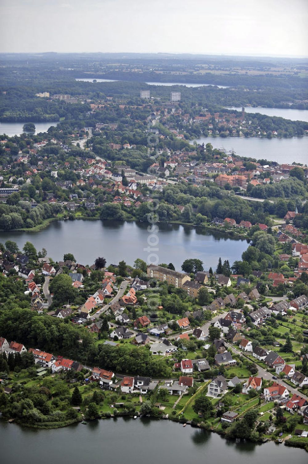 Plön from above - Blick über die Kreisstadt Plön. Sie hat etwa 13.000 Einwohner und liegt direkt am größten Binnensee Schleswig-Holsteins, dem Großen Plöner See. Wahrzeichen der Stadt ist das Schloss, das im 17. Jahrhundert erbaut wurde. View over the town Ploen. It has about 13,000 inhabitants and is located on the largest lake in Schleswig-Holstein, the Great Poen Lake. Landmark of the city is the castle which was built in the 17th Century.