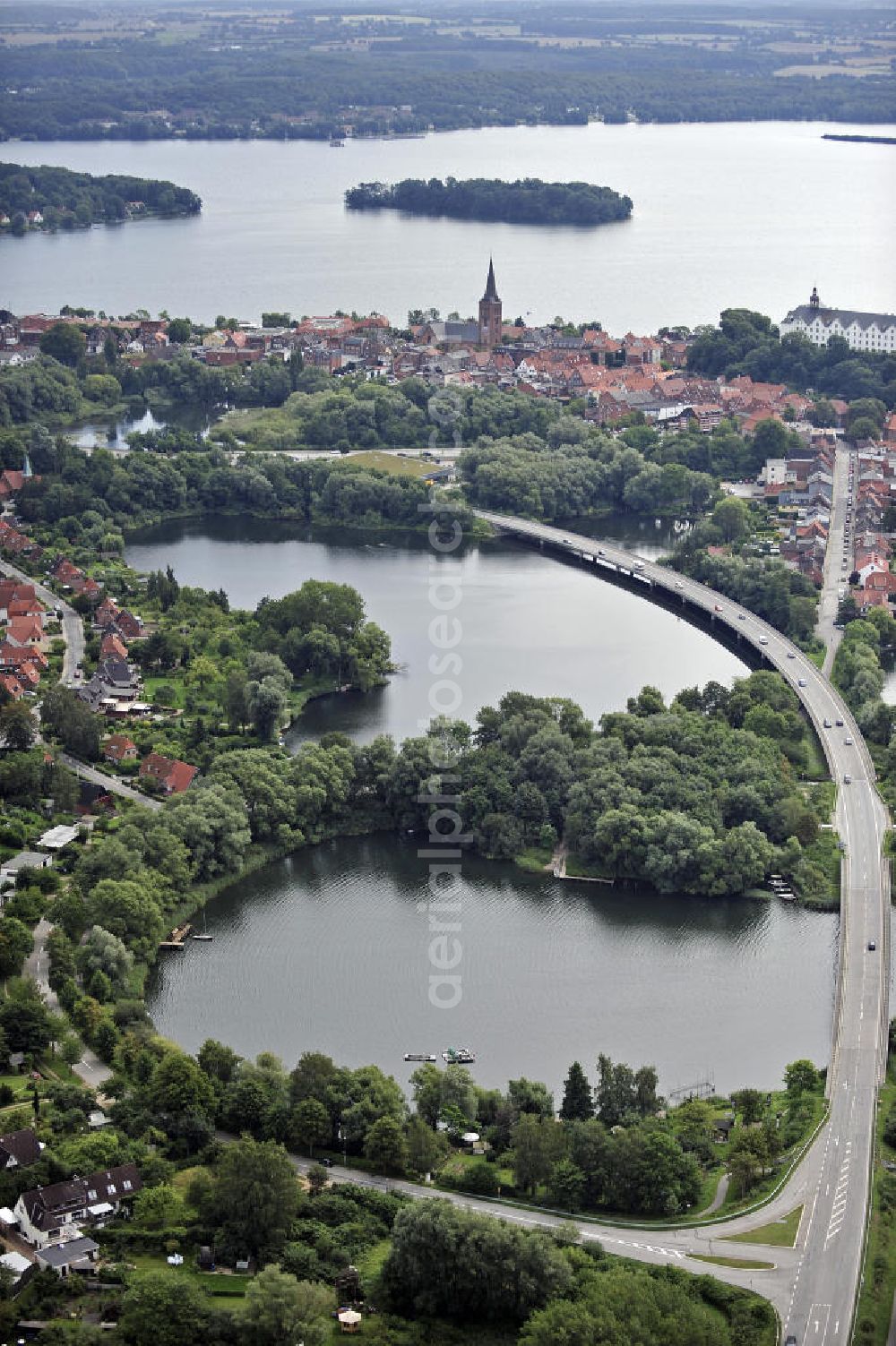 Plön from the bird's eye view: Blick über die Kreisstadt Plön. Sie hat etwa 13.000 Einwohner und liegt direkt am größten Binnensee Schleswig-Holsteins, dem Großen Plöner See. Wahrzeichen der Stadt ist das Schloss, das im 17. Jahrhundert erbaut wurde. View over the town Ploen. It has about 13,000 inhabitants and is located on the largest lake in Schleswig-Holstein, the Great Poen Lake. Landmark of the city is the castle which was built in the 17th Century.