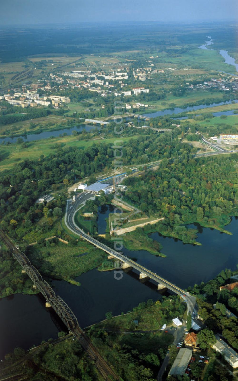 Küstriner Vorland from above - Blick von Küstrin-Kietz, einem Ortsteil der Gemeinde Küstriner Vorland, über die Oder auf Kostrzyn nad Odra ( deutsch Küstrin ) in Polen. Der größte Teil der ehemals beiderseits der Oder gelegenen Stadt wurde nach dem 2. Weltkrieg dem Staatsgebiet von Polen angegliedert, während der Ortsteil Küstrin-Kietz zum Bundesland Brandenburg gehört. Über die Oder führen am linken Bildrand die Eisenbahnbrücke und daneben die Brücke der polnischen Landesstraße / Droga krajowa DK 22 bzw. der Bundesstraße B 1 auf deutschem Gebiet.