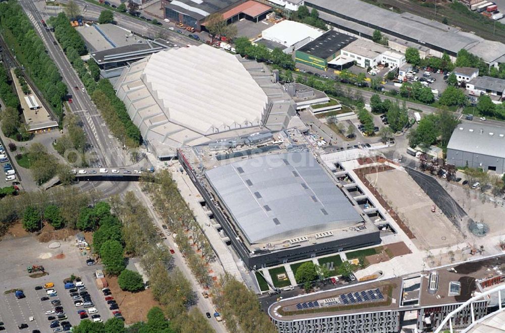 Aerial photograph Stuttgart - Blick auf die fertige Porsche Arena.Sieist eine Veranstaltungshalle in Stuttgart-Bad Cannstatt im NeckarPark. Die Halle liegt unmittelbar neben der Hanns-Martin-Schleyer-Halle an der Mercedesstraße. Beide Hallen sind über ein gemeinsames Foyer direkt miteinan der verbunden. Betreiber beider Hallen ist die Messegesellschaft Stuttgart.Nach 14-monatiger Bauzeit wurde die Arena am 27. Mai 2006 mit einem Festakt und einer Ausgabe der Fernsehshow „Verstehen Sie Spaß?“ eröffnet. Der Bau der Halle kostete 28 Millionen Euro, das gemeinsame Foyer mit der Schleyer-Halle 7,3 Millionen Euro.Zur Refinanzierung der Baukosten war bereits vor Baubeginn ein Verkauf der Namensrechte geplant. Die Dr. Ing. h.c. F. Porsche AG erwarb die Namensrechte für zehn Millionen Euro bei einer Laufzeit von 20 Jahren.Kurze Umrüstzeiten erlauben flexible Nutzungen der Arena für Handball, Basketball, Volleyball, Tennis, Eishockey, Tanzsport, Konzerte, Eisrevuen, Hauptversammlungen und Firmenevents.Die Halle hat die Dimension 135 x 95 m mit vier Vollgeschossen und insgesamt 9.400 m² Fläche. 20 Logen oberhalb der Zuschauerränge bieten Platz für bis zu 250 Personen. Die Fläche des Innenraums (mit festeingebauter Eisfläche) umfasst ca. 2.000 Quadratmeter. Die elliptischen Tribünen sorgen für gute Sichtverhältnisse. Je nach Veranstaltung haben bis zu 7.500 Besucher in der Porsche-Arena Platz.Der Porsche Tennis Grand Prix, der bis 2005 in Filderstadt stattfand, findet seit 2006 in der Porsche-Arena statt.