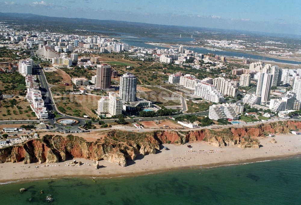 Aerial image Praia da Rocha - Blick auf Praia da Rocha, ein beliebter Strand an der Algarve in Portugal. Entstanden ist der ca. 1,5 km lange Küstenabschnitt durch die Meeresauswaschung von härteren Felsgestein aus dem sie umgebendem weicheren Material an der hier ca. 20-30 m hohen Steilküste. Oberhalb der Steilkante haben sich zahlreiche Hotels, Ferienwohnungen, Restaurants und Geschäfte den Standortvorteil gesichert.