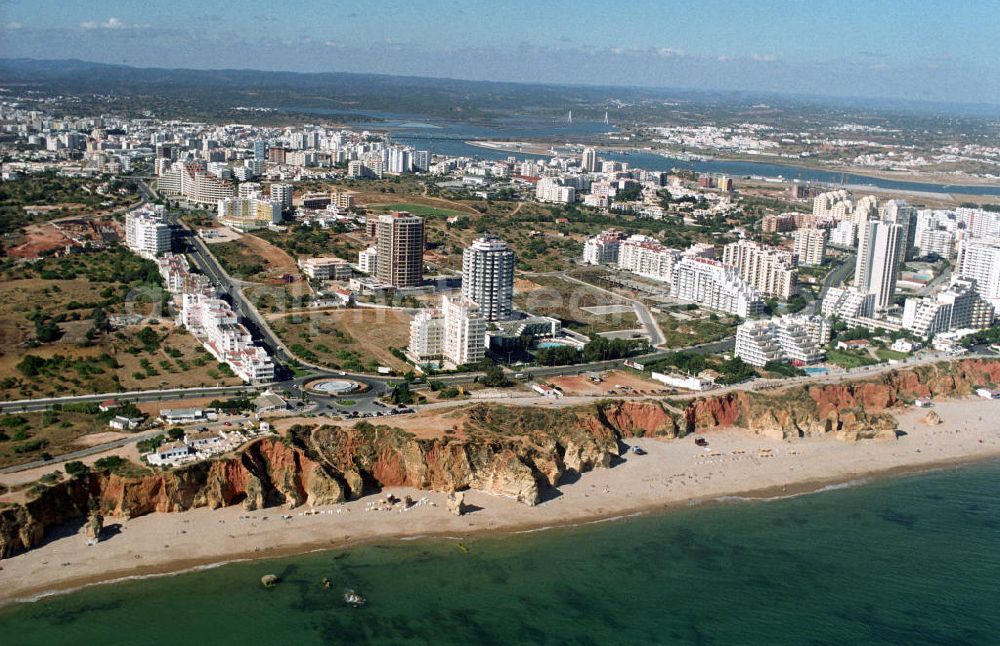 Praia da Rocha from above - Blick auf Praia da Rocha, ein beliebter Strand an der Algarve in Portugal. Entstanden ist der ca. 1,5 km lange Küstenabschnitt durch die Meeresauswaschung von härteren Felsgestein aus dem sie umgebendem weicheren Material an der hier ca. 20-30 m hohen Steilküste. Oberhalb der Steilkante haben sich zahlreiche Hotels, Ferienwohnungen, Restaurants und Geschäfte den Standortvorteil gesichert.