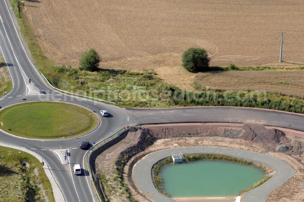 Aerial photograph Eisenach - Blick auf ein Regenrückhaltebecken am Kreisverkehr im Nordteil der Baustelle Ausfahrt / Anschlussstelle Eisenach-West der A4. Der Neubau ist Teil des Projekt Nordverlegung / Umfahrung Hörselberge der Autobahn E40 / A4 in Thüringen bei Eisenach. Durchgeführt werden die im Zuge dieses Projektes notwendigen Arbeiten unter an derem von den Mitarbeitern der Niederlassung Weimar der EUROVIA Verkehrsbau Union sowie der Niederlassungen Abbruch und Erdbau, Betonstraßenbau, Ingenieurbau und TECO Schallschutz der EUROVIA Beton sowie der DEGES.