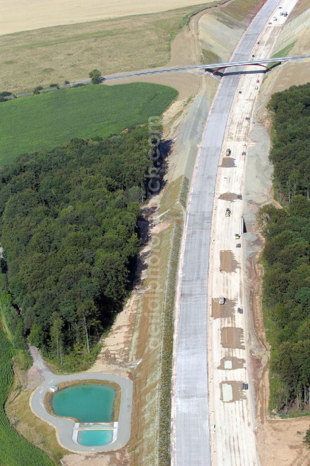 Aerial photograph Madelungen - Blick auf die Baustelle der A4 entlang des Madelunger Forst mit einem Regenrückhaltebecken, einer Unterführung sowie einer Strassenbrücke südlich von Madelungen. Für die Autobahn wurden in diesem Buchen-Wald ca. 12 Hektar Bäume abgeholzt. Der Neubau ist Teil des Projekt Nordverlegung / Umfahrung Hörselberge der Autobahn E40 / A4 in Thüringen bei Eisenach. Durchgeführt werden die im Zuge dieses Projektes notwendigen Arbeiten unter an derem von den Mitarbeitern der Niederlassung Weimar der EUROVIA Verkehrsbau Union sowie der Niederlassungen Abbruch und Erdbau, Betonstraßenbau, Ingenieurbau und TECO Schallschutz der EUROVIA Beton sowie der DEGES.