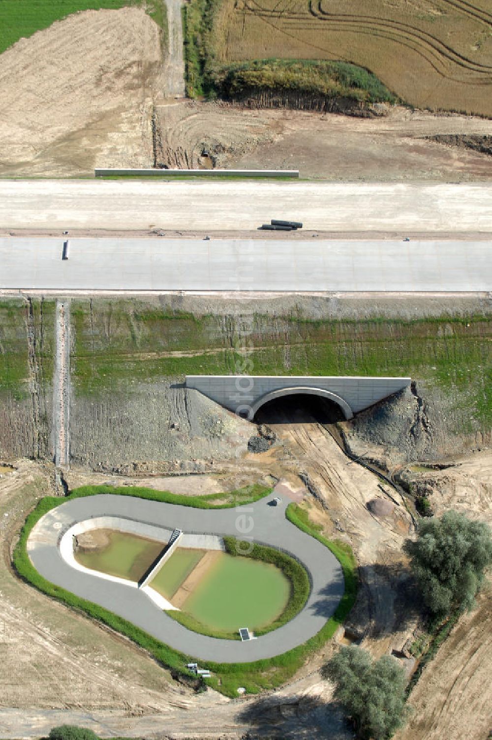 Madelungen from the bird's eye view: lick auf die Baustelle einer Unterführung der A4 mit Regenrückhaltebecken bei Madelungen. Der Neubau ist Teil des Projekt Nordverlegung / Umfahrung Hörselberge der Autobahn E40 / A4 in Thüringen bei Eisenach. Durchgeführt werden die im Zuge dieses Projektes notwendigen Arbeiten unter an derem von den Mitarbeitern der Niederlassung Weimar der EUROVIA Verkehrsbau Union sowie der Niederlassungen Abbruch und Erdbau, Betonstraßenbau, Ingenieurbau und TECO Schallschutz der EUROVIA Beton sowie der DEGES.