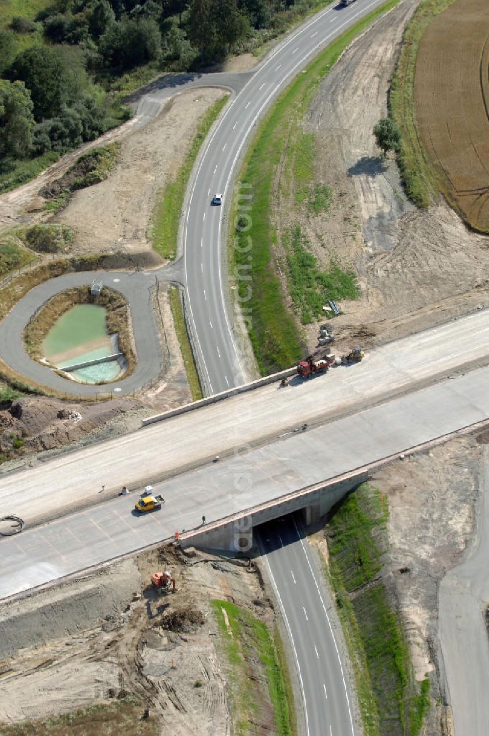 Neukirchen from the bird's eye view: Blick auf die Baustelle einer Unterführung der A4 für die Strassenverbindung zwischen Stregda und Neukirchen, sowie ein Regenrückhaltebecken. Der Neubau ist Teil des Projekt Nordverlegung / Umfahrung Hörselberge der Autobahn E40 / A4 in Thüringen bei Eisenach. Durchgeführt werden die im Zuge dieses Projektes notwendigen Arbeiten unter an derem von den Mitarbeitern der Niederlassung Weimar der EUROVIA Verkehrsbau Union sowie der Niederlassungen Abbruch und Erdbau, Betonstraßenbau, Ingenieurbau und TECO Schallschutz der EUROVIA Beton sowie der DEGES.