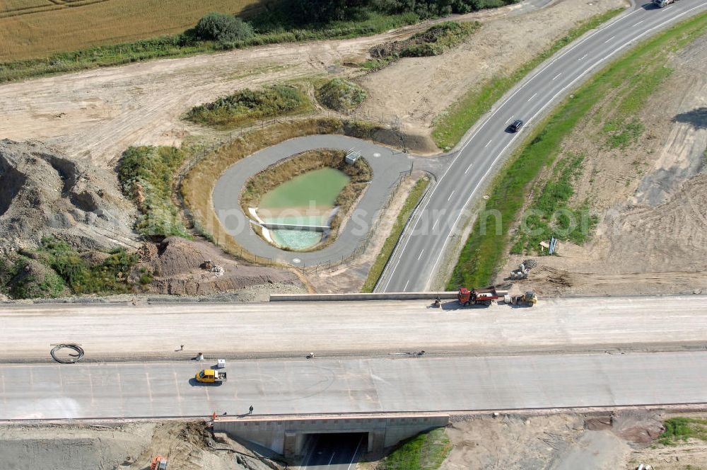 Aerial photograph Neukirchen - Blick auf die Baustelle einer Unterführung der A4 für die Strassenverbindung zwischen Stregda und Neukirchen, sowie ein Regenrückhaltebecken. Der Neubau ist Teil des Projekt Nordverlegung / Umfahrung Hörselberge der Autobahn E40 / A4 in Thüringen bei Eisenach. Durchgeführt werden die im Zuge dieses Projektes notwendigen Arbeiten unter an derem von den Mitarbeitern der Niederlassung Weimar der EUROVIA Verkehrsbau Union sowie der Niederlassungen Abbruch und Erdbau, Betonstraßenbau, Ingenieurbau und TECO Schallschutz der EUROVIA Beton sowie der DEGES.