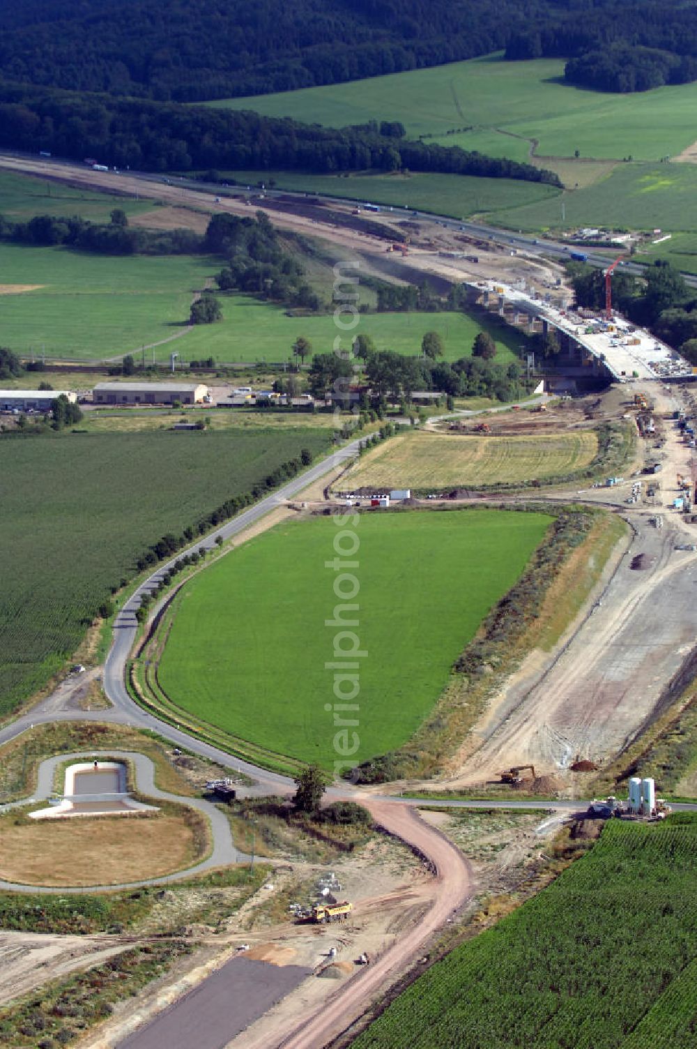 Aerial image Sättelstädt - Blick auf die Baustelle der Ausfahrt / Anschlussstelle Sättelstädt der A4 mit Regenrückhaltebecken VI und der Hörsetalbrücke im Hintergrund. Der Neubau ist Teil des Projekt Nordverlegung / Umfahrung Hörselberge der Autobahn E40 / A4 in Thüringen bei Eisenach. Durchgeführt werden die im Zuge dieses Projektes notwendigen Arbeiten unter an derem von den Mitarbeitern der Niederlassung Weimar der EUROVIA Verkehrsbau Union sowie der Niederlassungen Abbruch und Erdbau, Betonstraßenbau, Ingenieurbau und TECO Schallschutz der EUROVIA Beton sowie der DEGES.