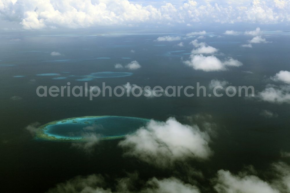 Dharanboodhoo from the bird's eye view: Cumulus clouds overcast Coastal Indian Ocean - island in Dhahran Boodhoo in Central Province, Maldives