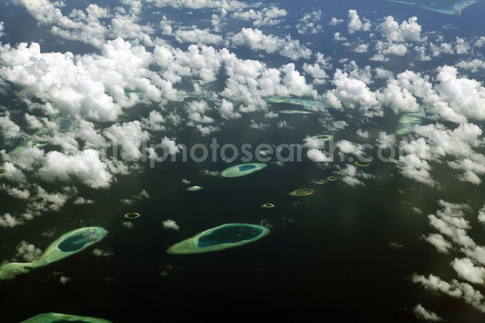 Dharanboodhoo from the bird's eye view: Cumulus clouds overcast Coastal Indian Ocean - island in Dhahran Boodhoo in Central Province, Maldives