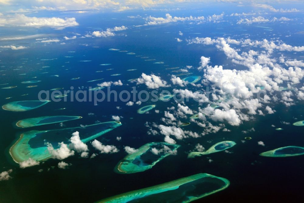 Dharanboodhoo from the bird's eye view: Cumulus clouds overcast Coastal Indian Ocean - island in Dhahran Boodhoo in Central Province, Maldives