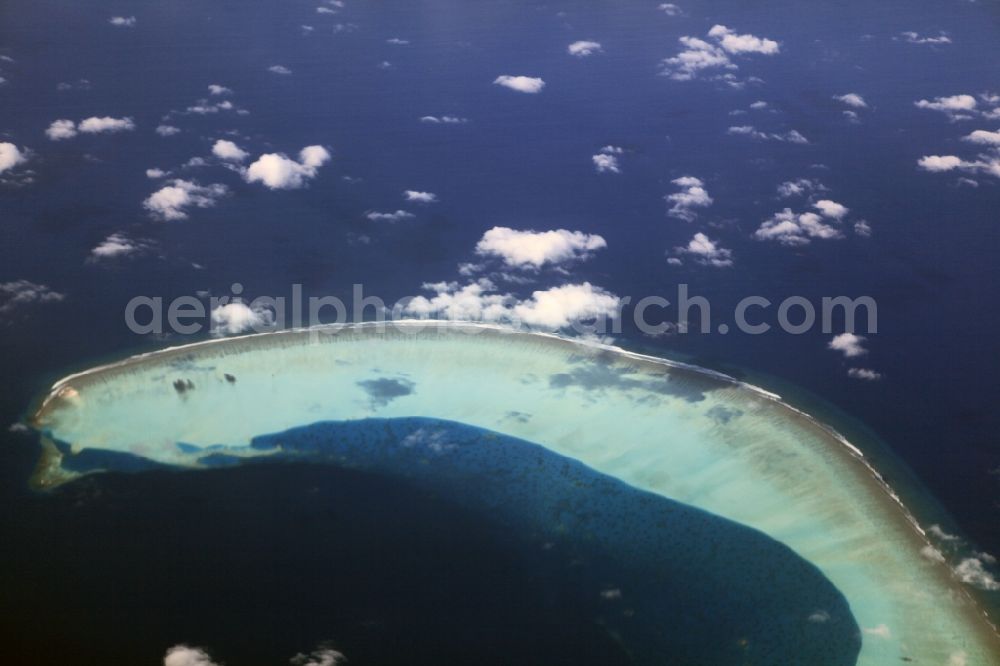 Dharanboodhoo from the bird's eye view: Cumulus clouds overcast Coastal Indian Ocean - island in Dhahran Boodhoo in Central Province, Maldives