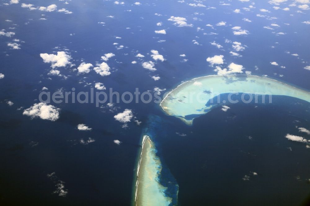 Dharanboodhoo from the bird's eye view: Cumulus clouds overcast Coastal Indian Ocean - island in Dhahran Boodhoo in Central Province, Maldives