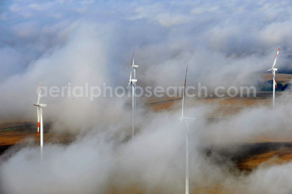 Werneuchen Ortsteil Seefeld from above - High fog-like cloud layers imposed by the source view of a wind turbine for electricity generation in the Brandenburg town of Seefeld. The rotors of the Vestas wind turbines stand out from the clouds widely visible