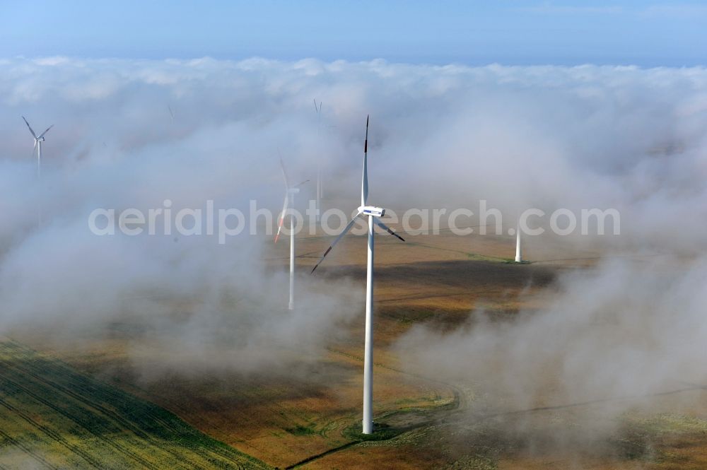 Werneuchen Ortsteil Seefeld from the bird's eye view: High fog-like cloud layers imposed by the source view of a wind turbine for electricity generation in the Brandenburg town of Seefeld. The rotors of the Vestas wind turbines stand out from the clouds widely visible