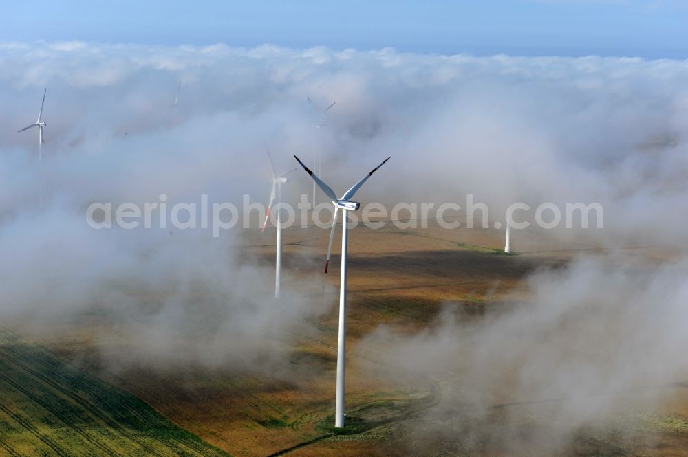 Aerial image Werneuchen Ortsteil Seefeld - High fog-like cloud layers imposed by the source view of a wind turbine for electricity generation in the Brandenburg town of Seefeld. The rotors of the Vestas wind turbines stand out from the clouds widely visible