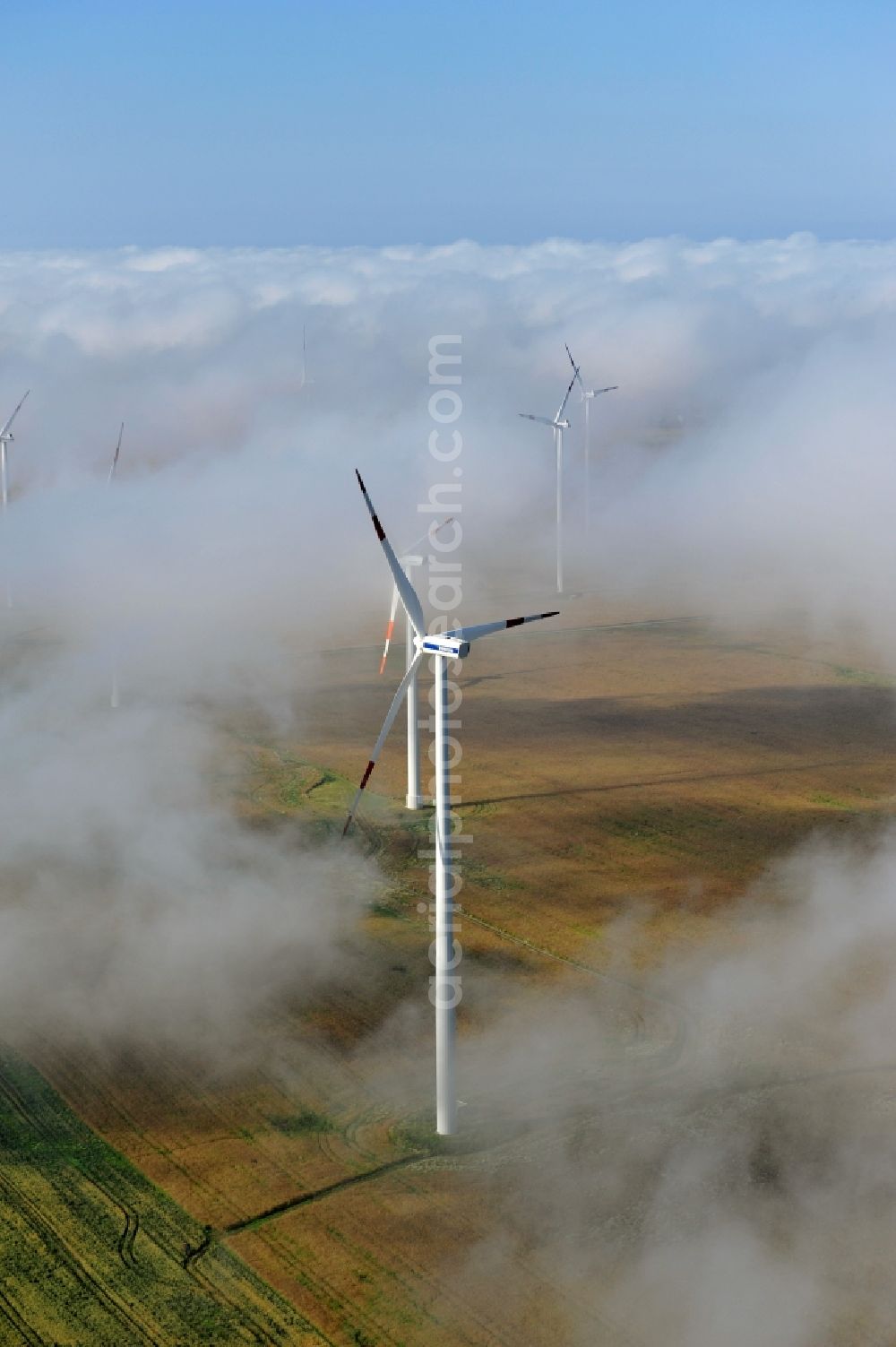 Werneuchen Ortsteil Seefeld from above - High fog-like cloud layers imposed by the source view of a wind turbine for electricity generation in the Brandenburg town of Seefeld. The rotors of the Vestas wind turbines stand out from the clouds widely visible