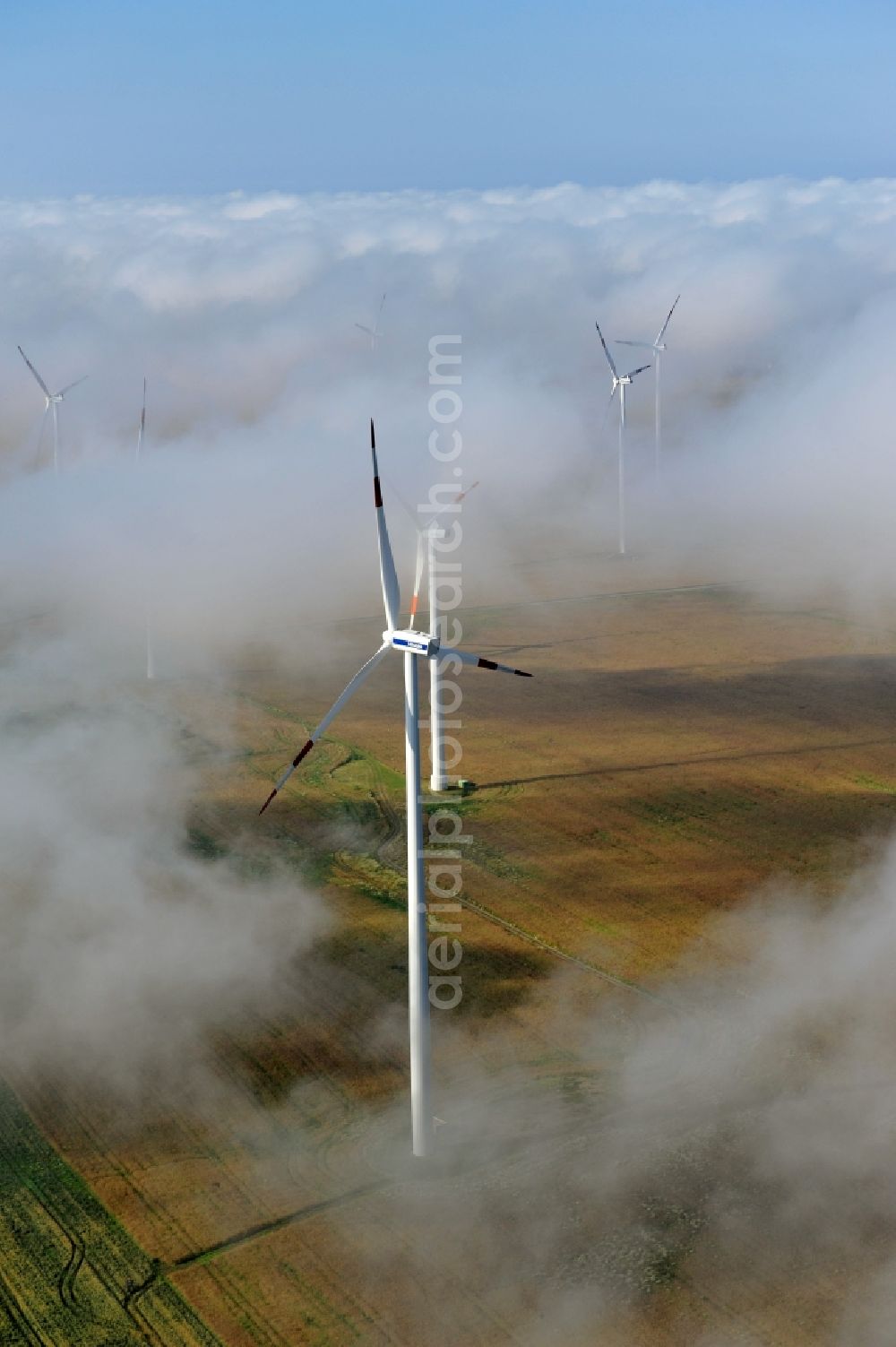 Aerial image Werneuchen Ortsteil Seefeld - High fog-like cloud layers imposed by the source view of a wind turbine for electricity generation in the Brandenburg town of Seefeld. The rotors of the Vestas wind turbines stand out from the clouds widely visible