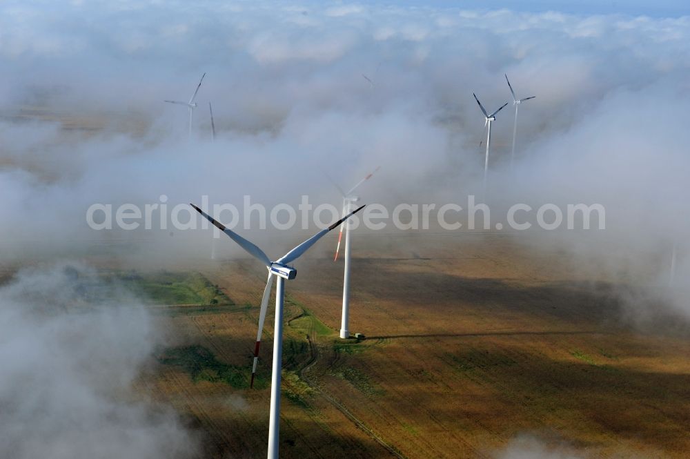 Werneuchen Ortsteil Seefeld from above - High fog-like cloud layers imposed by the source view of a wind turbine for electricity generation in the Brandenburg town of Seefeld. The rotors of the Vestas wind turbines stand out from the clouds widely visible