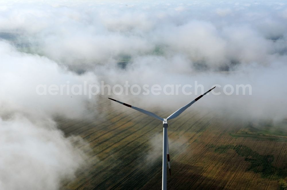 Werneuchen Ortsteil Seefeld from the bird's eye view: High fog-like cloud layers imposed by the source view of a wind turbine for electricity generation in the Brandenburg town of Seefeld. The rotors of the Vestas wind turbines stand out from the clouds widely visible