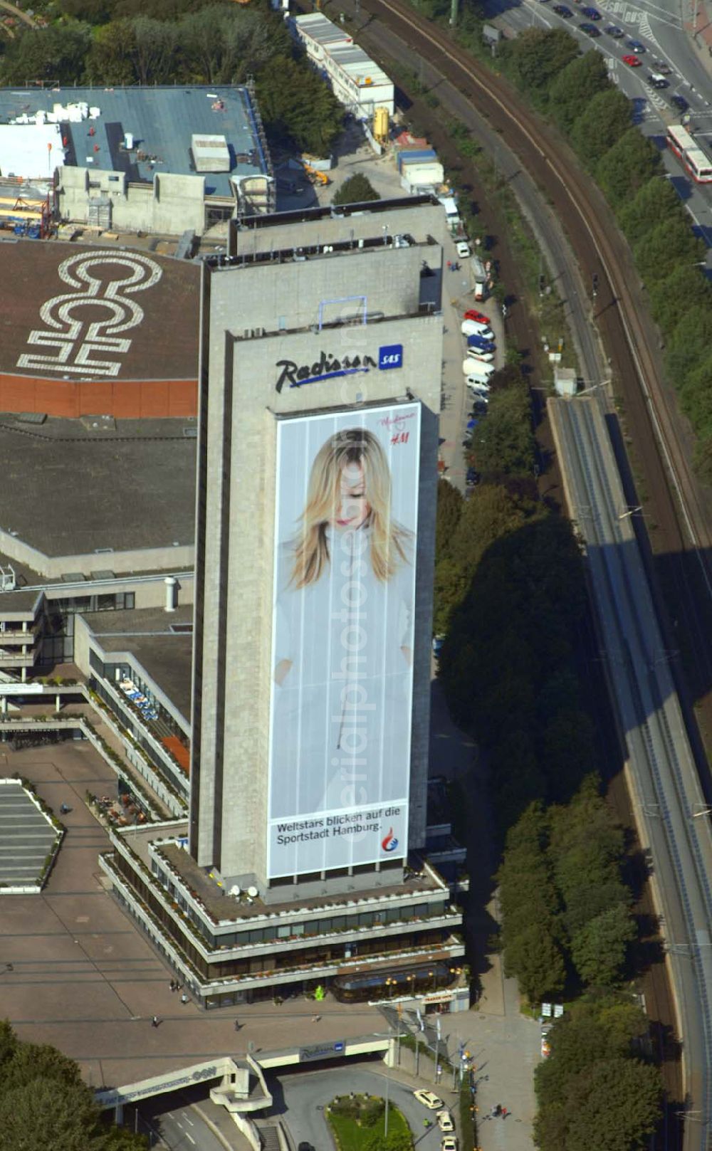 Aerial image Hamburg - Blick auf das Hotel Radisson (Marseiller Str.2) und das Congress Centrum CCH ( Am Dammtor) in Hamburg mit der H&M Reklame. Tel. 01805-624009. Das 4 Sterne First-Class Hotel mit spektakulärer Aussicht auf die Stadt bietet außergewöhnlichen Komfort und Service. Dies gewährleistet beispielsweise die Garantie für 100% Gästezufriedenheit, Check-out bis 15:00 Uhr, kostenloses Grab & Run, sowie 24-Stunden-Zimmerservice. Im Herzen der Stadt, inmitten des botanischen Gartens Planten un Blomen gelegen, in Fußdistanz zum ICE-Dammtor-Bahnhof und zur Alster. Direkter Zugang zum Congress Centrum Hamburg, dem CCH.