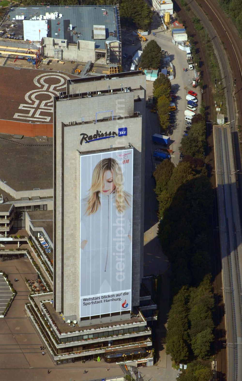 Hamburg from above - Blick auf das Hotel Radisson (Marseiller Str.2) und das Congress Centrum CCH ( Am Dammtor) in Hamburg mit der H&M Reklame. Tel. 01805-624009. Das 4 Sterne First-Class Hotel mit spektakulärer Aussicht auf die Stadt bietet außergewöhnlichen Komfort und Service. Dies gewährleistet beispielsweise die Garantie für 100% Gästezufriedenheit, Check-out bis 15:00 Uhr, kostenloses Grab & Run, sowie 24-Stunden-Zimmerservice. Im Herzen der Stadt, inmitten des botanischen Gartens Planten un Blomen gelegen, in Fußdistanz zum ICE-Dammtor-Bahnhof und zur Alster. Direkter Zugang zum Congress Centrum Hamburg, dem CCH.