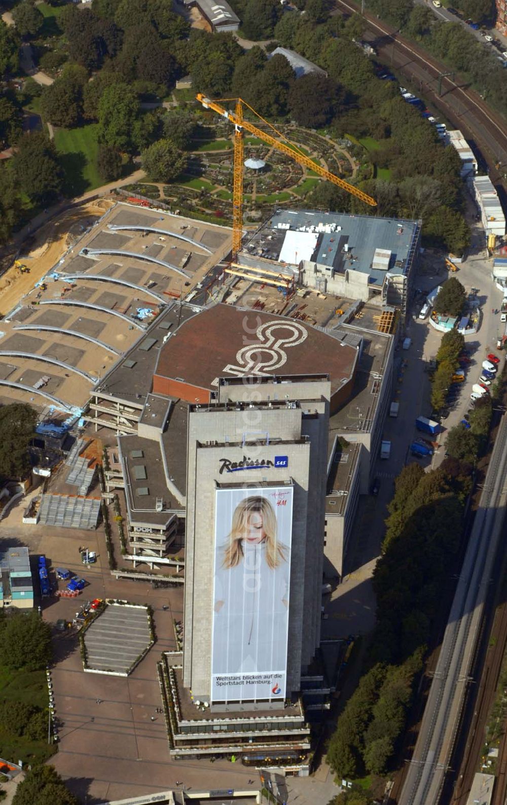 Aerial photograph Hamburg - Blick auf das Hotel Radisson (Marseiller Str.2) und das Congress Centrum CCH ( Am Dammtor) in Hamburg mit der H&M Reklame. Tel. 01805-624009. Das 4 Sterne First-Class Hotel mit spektakulärer Aussicht auf die Stadt bietet außergewöhnlichen Komfort und Service. Dies gewährleistet beispielsweise die Garantie für 100% Gästezufriedenheit, Check-out bis 15:00 Uhr, kostenloses Grab & Run, sowie 24-Stunden-Zimmerservice. Im Herzen der Stadt, inmitten des botanischen Gartens Planten un Blomen gelegen, in Fußdistanz zum ICE-Dammtor-Bahnhof und zur Alster. Direkter Zugang zum Congress Centrum Hamburg, dem CCH.