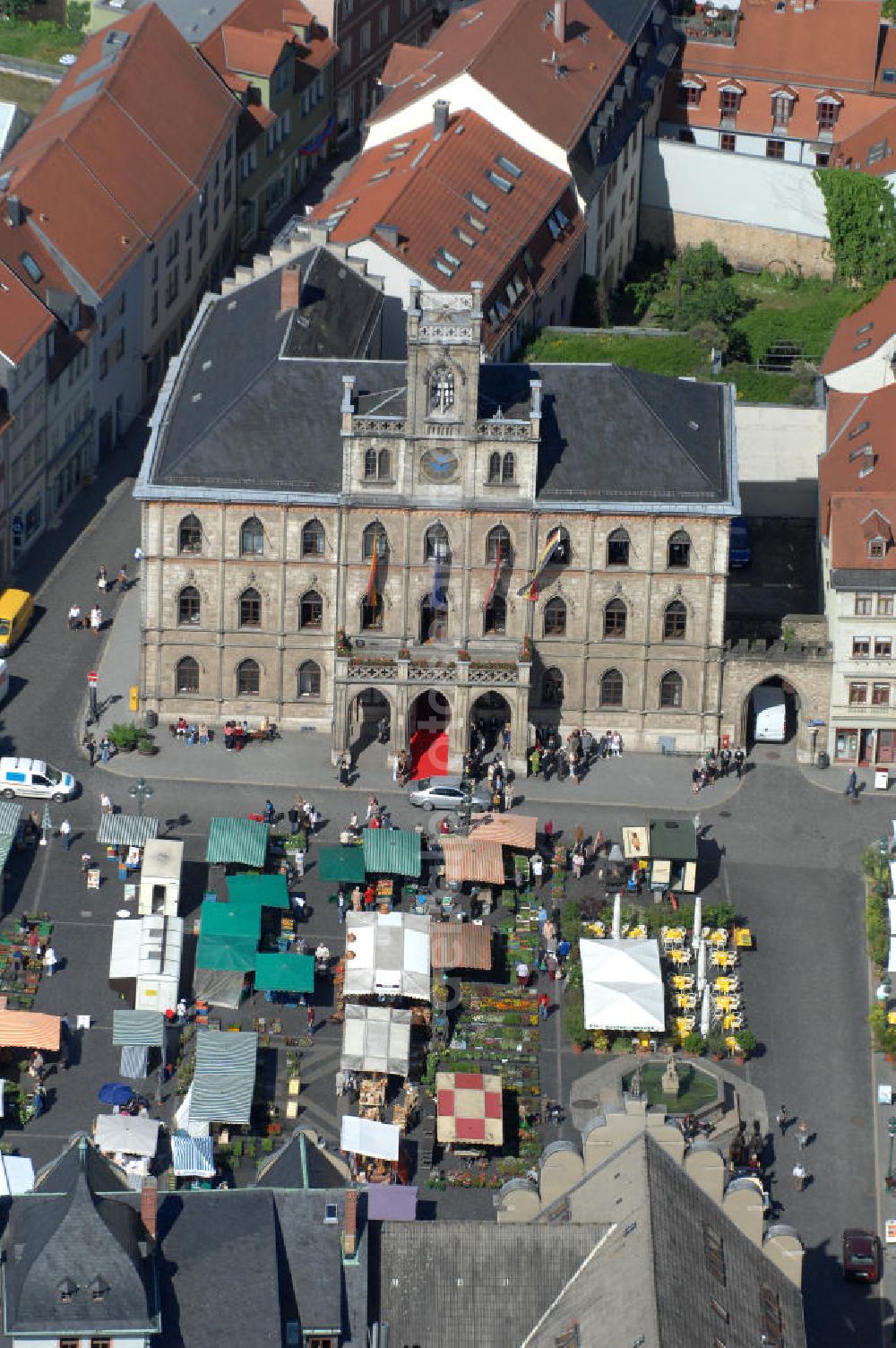 Weimar from above - Blick auf das Weimarer Rathaus , es befindet sich im Zentrum Weimars auf der Westseite des Marktplatzes. Der dreigeschossige Bau in neugotischem Stil mit repräsentativem Balkon und Glockenturm ist eines der Wahrzeichen der Stadt Weimar. Neben der Stadtverwaltung ist im Rathaus auch das Stadtarchiv untergebracht. View of the Weimar City Hall, it is in the center of Weimar, on the west side of the square. The three-storey building in neo-Gothic style, with prestigious balcony and bell tower is a landmark in the city of Weimar.