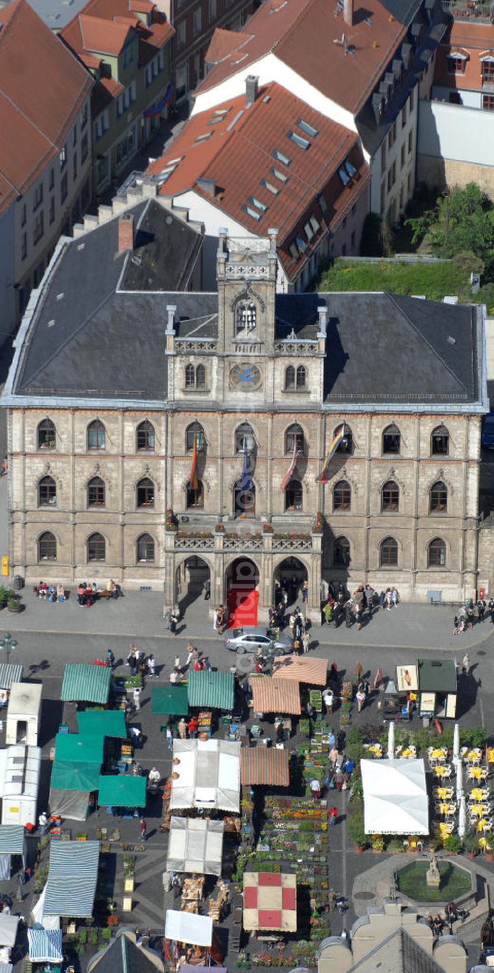 Weimar from the bird's eye view: Blick auf das Weimarer Rathaus , es befindet sich im Zentrum Weimars auf der Westseite des Marktplatzes. Der dreigeschossige Bau in neugotischem Stil mit repräsentativem Balkon und Glockenturm ist eines der Wahrzeichen der Stadt Weimar. Neben der Stadtverwaltung ist im Rathaus auch das Stadtarchiv untergebracht. View of the Weimar City Hall, it is in the center of Weimar, on the west side of the square. The three-storey building in neo-Gothic style, with prestigious balcony and bell tower is a landmark in the city of Weimar.