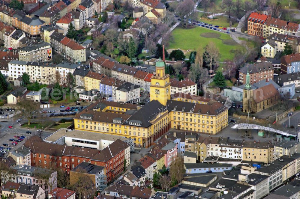 Aerial image WITTEN - Witten-Mitte ist einer der acht Stadtteile der Stadt Witten an der Ruhr. Er besteht aus den Wittener Stadtteilbezirken Innenstadt,Oberdorf-Helenenberg, Industriegürtel-West, Krone, Crengeldanz, Hauptfriedhof, Stadion, Industriegürtel-Nord und Hohenstein. In Witten-Mitte leben 33.770 Menschen. 1862 mietete die Stadt Witten ein Privathaus nahe dem Marktplatz an, um in diesem Haus die Verwaltung der wachsenden Stadt unterzubringen. Am 25. Oktober 1911 schrieb der Magistrat schließlich einen Wettbewerb zum Neubau eines Rathauses aus, den der Berliner Architekt Heinrich Jennen gewann. Durch den Ausbruch des Ersten Weltkrieges wurde erst am 7. Juli 1921 von der Stadtverordnetenversammlung der Baubeginn beschlossen. Mit der Ruhrbesetzung durch französische Truppen 1923 und der hohen Inflation der Zeit, gerieten die Bauarbeiten immer wieder ins Stocken. Der erste Bauabschnitt war 1924 soweit abgeschlossen, dass das Rathaus teilweise bezogen werden konnte. Die Verwaltung war angehalten, die Büros schnell in Besitz zu nehmen, um einer Besetzung der Räumlichkeiten durch die französischen Besatzungstruppen zuvorzukommen. Im Juli 1924 wurde das Hauptgebäude endgültig seiner Bestimmung übergeben. Im gleichen Monat begannen die Bauarbeiten des prägnanten Turms, der zusammen mit der gegenüberliegenden Johanniskirche seit seiner Fertigstellung das Gesicht von Witten-Mitte und damit der Wittener Innenstadt prägt. Ursprünglich sollte die Spitze des Turms eine auf einem Sockel stehende Bronzestatue zieren, deren Anfertigung allerdings 10.000 Reichsmark gekostet hätte. Da der Stadt 1924 jedoch das Geld für eine solche Anfertigung fehlte, wurde die Anfertigung der Statue aufgeschoben und stattdessen die Turmspitze mit einer Fiale aus Kupferblech im Jahre 1926 abgeschlossen. Dieses Provisorium ziert bis heute die Spitze des Wittener Rathausturms.