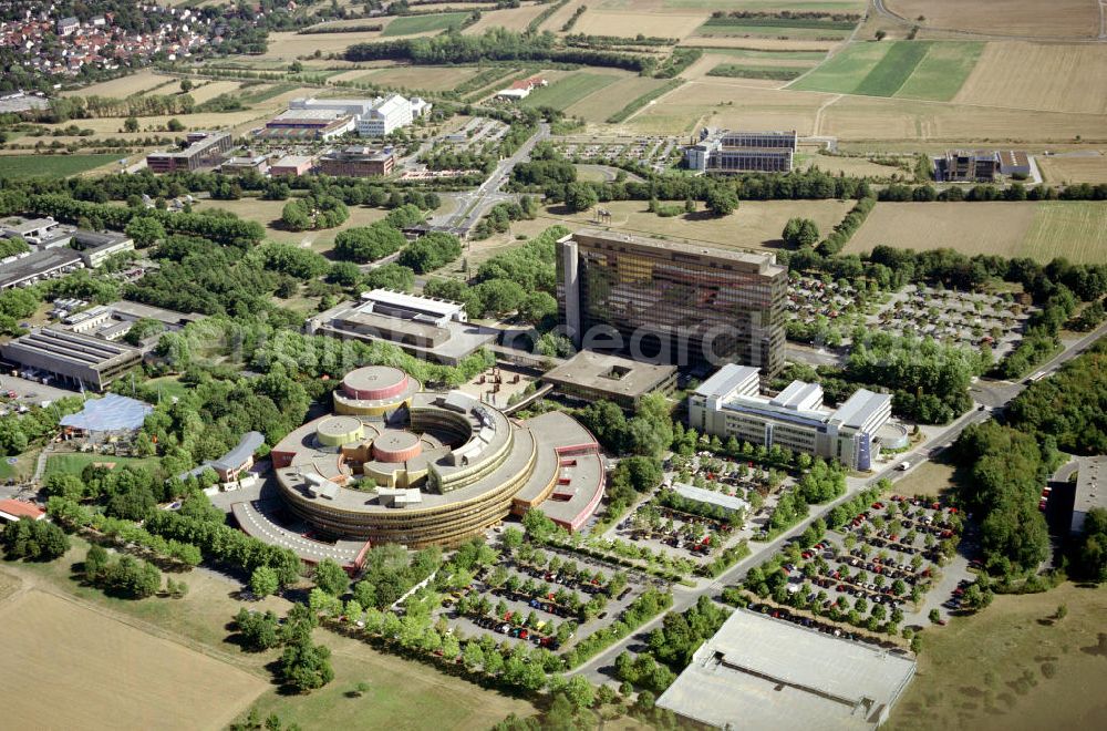 Aerial photograph MAINZ - Redaktions- und Verwaltungsgebäude des ZDF in Mainz-Lerchenberg. Das ZDF („Zweites Deutsches Fernsehen“) ist eine öffentlich-rechtliche Sendeanstalt in Deutschland und eine der größten Sendeanstalten in Europa. Gemeinsam mit der ARD und dem Deutschlandradio bildet das ZDF den öffentlich-rechtlichen Rundfunk in Deutschland. Hierzu kaufte das ZDF am 25. Juni 1964 ein 1,04 Mio. m² großes, im Mainzer Stadtteil Lerchenberg gelegenes Grundstück. Im ersten Bauabschnitt konnte ein Gebäude für die Übertragungswagen Anfang 1967 bezogen werden; der zweite Abschnitt, das 14-stöckige Redaktions- und Verwaltungsgebäude im Frühjahr 1974. Am 15. September 1977 begannen die Erdarbeiten für den 3. Bauabschnitt des Sendebetriebsgebäudes, einen von der Planungsgruppe Stieldorf, unter an deren von Peter Türler und Wolf Nöhren, entworfenen Rundbau (mit dem größten Durchmesser von 166 Metern). Nach sechsjähriger Bauzeit nahm dann schließlich am 6. Dezember 1984 das neue Sendezentrum (das größte in Europa) seinen Betrieb auf.