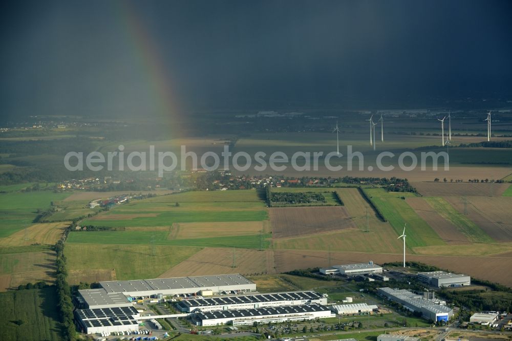 Aerial photograph Nauen - Rainbow over the production facilities and company buildings of BSH House machines Nauen GmbH in Nauen in the state of Brandenburg. The works include a cargo and logistics centre. The site is located on the edge of a field