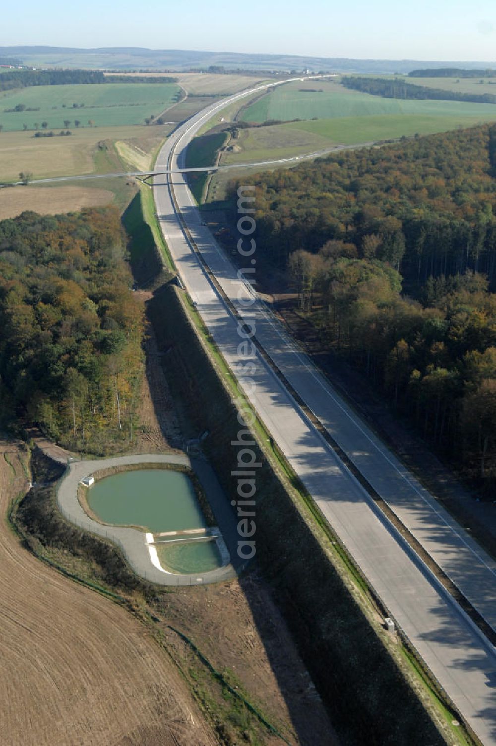 Aerial photograph Madelungen - Blick auf ein Regenrückhaltebecken neben der A4 nahe der Unterführung südlich von Madelungen im Madelungener Forst. Der Neubau ist Teil des Projekt Nordverlegung / Umfahrung Hörselberge der Autobahn E40 / A4 in Thüringen bei Eisenach. Durchgeführt werden die im Zuge dieses Projektes notwendigen Arbeiten unter an derem von den Mitarbeitern der Niederlassung Weimar der EUROVIA Verkehrsbau Union sowie der Niederlassungen Abbruch und Erdbau, Betonstraßenbau, Ingenieurbau und TECO Schallschutz der EUROVIA Beton sowie der DEGES.