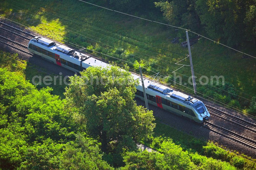 Aerial image Kemberg - Regional train and passenger train of S-Bahn Mitteldeutschland in motion on the tracks of the route on street Bahnwaerterhaus in Kemberg in the state Saxony-Anhalt, Germany